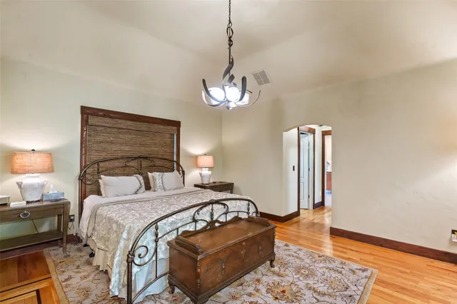 a bedroom with bed and wooden floor