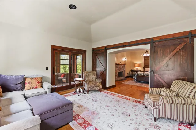 a living room with furniture two large window and a rug