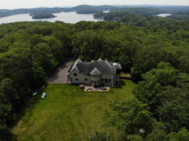 an aerial view of a house with yard and green space