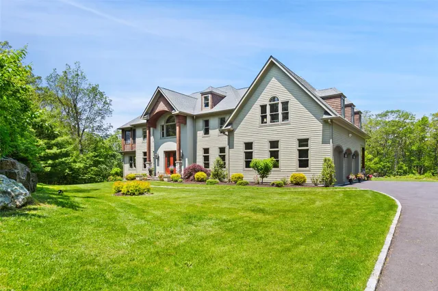 a front view of a house with a yard and trees