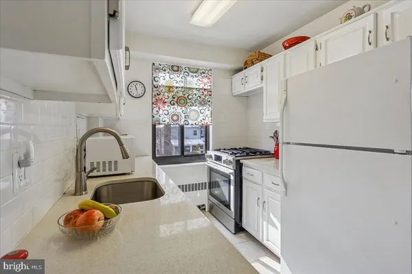 a kitchen with stainless steel appliances a sink a refrigerator and cabinets