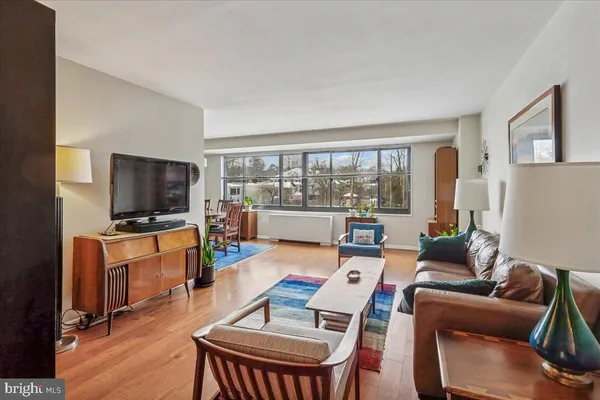 a living room with furniture a flat screen tv and a floor to ceiling window