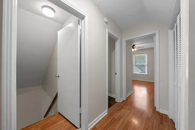 a view of a hallway with wooden floor