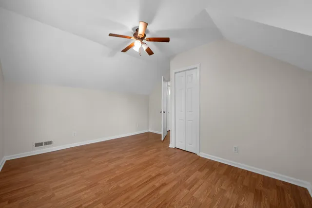 a view of a room with wooden floor and ceiling fan