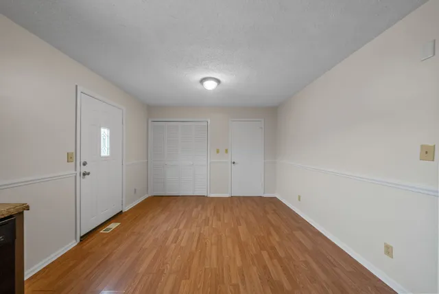 a view of a room with wooden floor