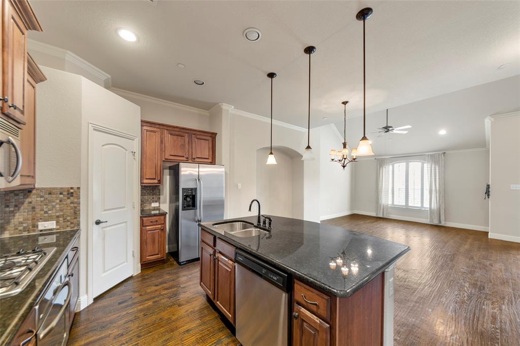 7929 Maddox Road Plano, TX 75024 - Photo 3 of 26 Another view of spacious kitchen with open concept dining and living space. Kitchen island offers another dining space. Also features SS appliances, walk in pantry and gas cook top.