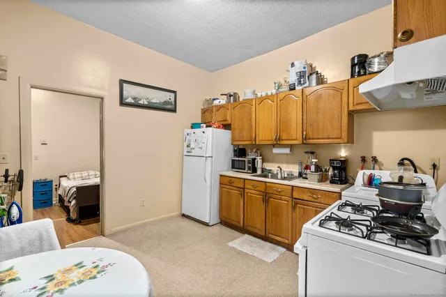 a kitchen with stainless steel appliances kitchen island granite countertop a refrigerator and a stove top oven