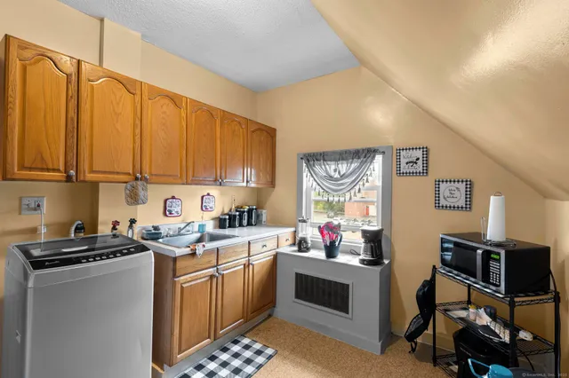 a kitchen that has a sink cabinets counter space and a window