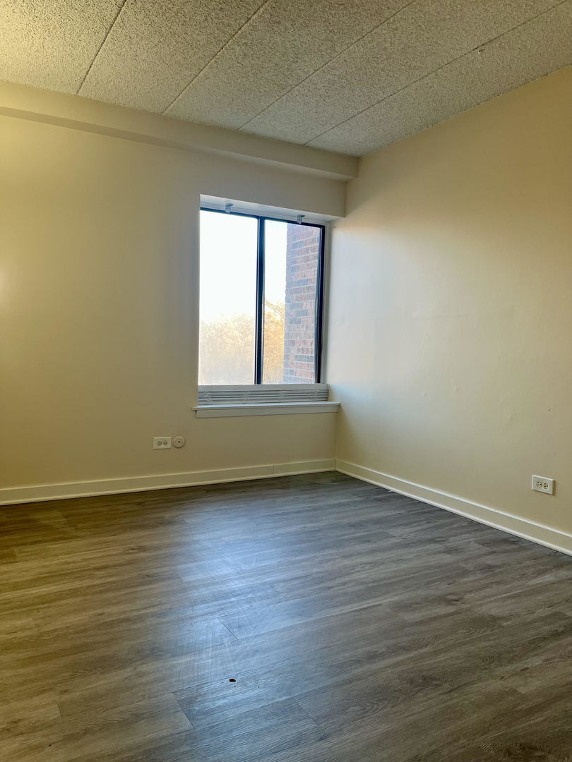 5515 Cromwell Lane, Unit M2 Oak Forest, IL 60452 - Photo 24 of 25 a view of an empty room with wooden floor and a window