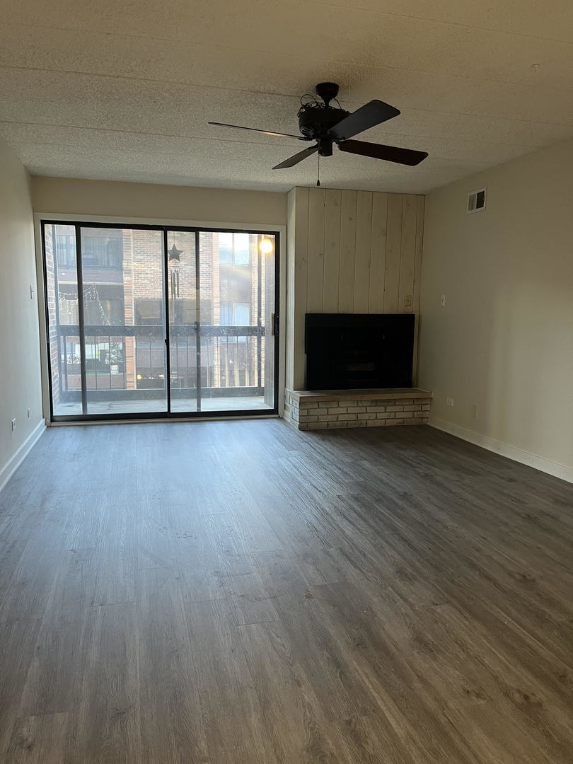5515 Cromwell Lane, Unit M2 Oak Forest, IL 60452 - Photo 8 of 25 a view of empty room with wooden floor and fireplace