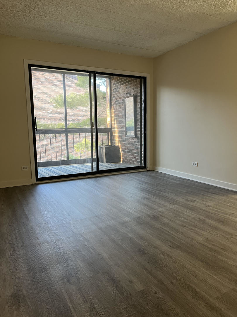 5515 Cromwell Lane, Unit M2 Oak Forest, IL 60452 - Photo 9 of 25 a view of an empty room with wooden floor and a window