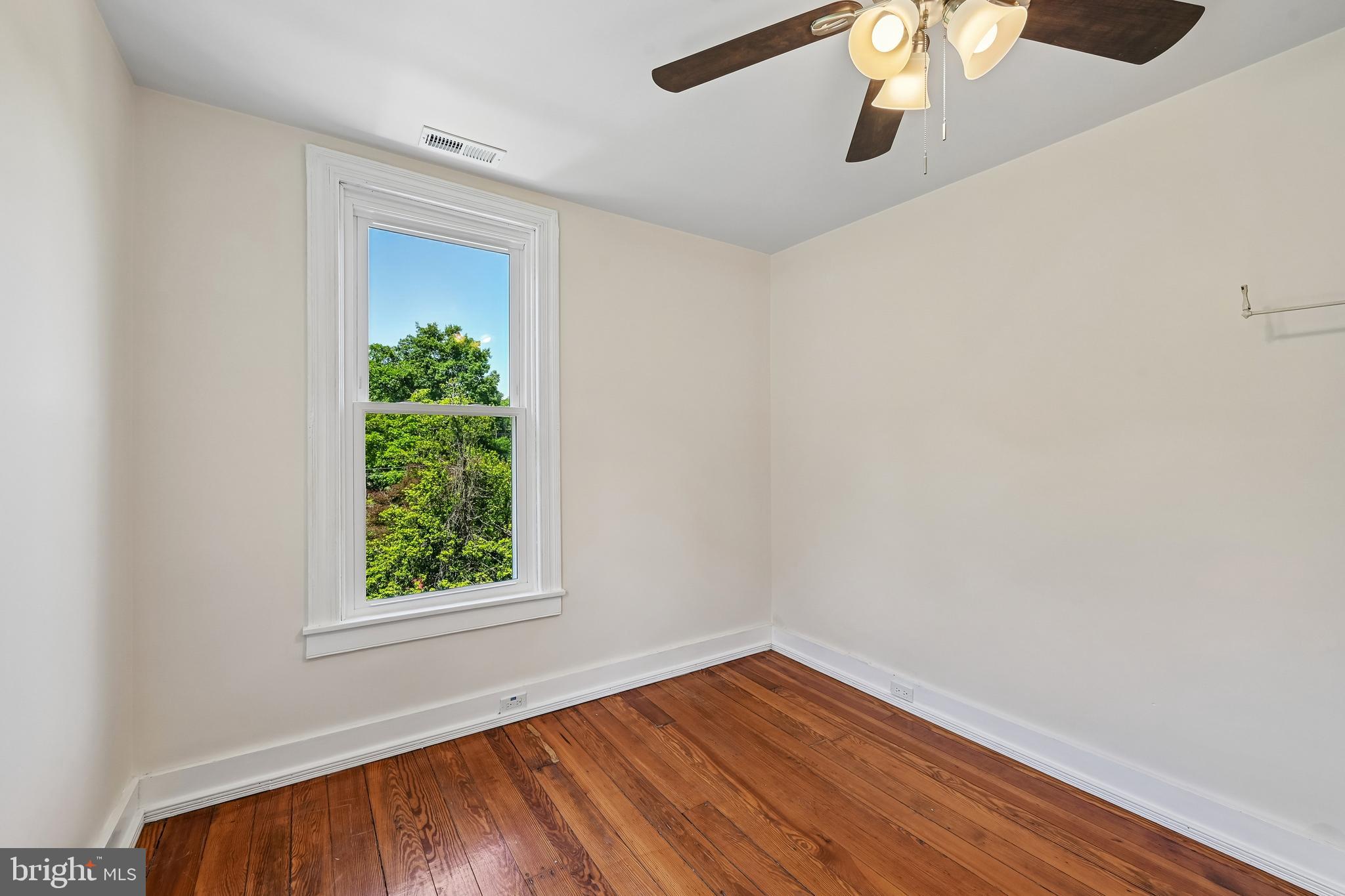 5702 Falls Road Baltimore, MD 21209 - Photo 29 of 49 an empty room with wooden floor and windows