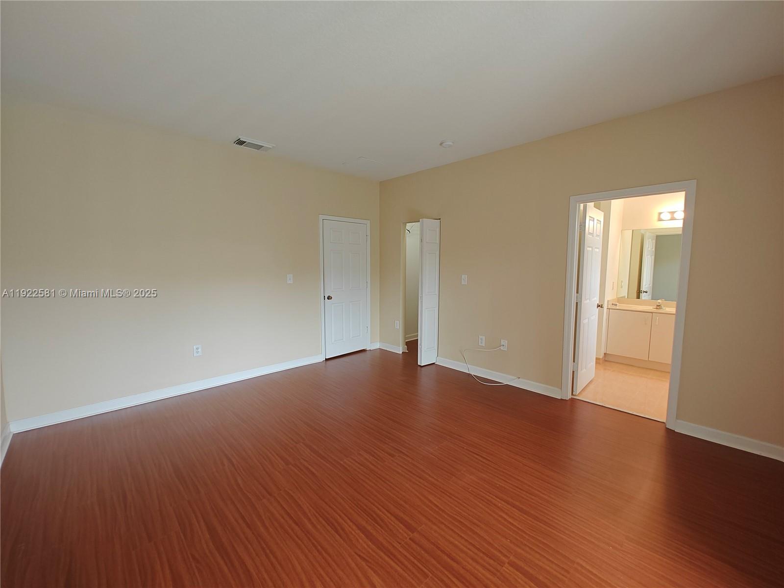 11252 Southwest 230th Terrace, Unit 11252 Miami, FL 33170 - Photo 13 of 28 a view of an empty room with wooden floor and a window