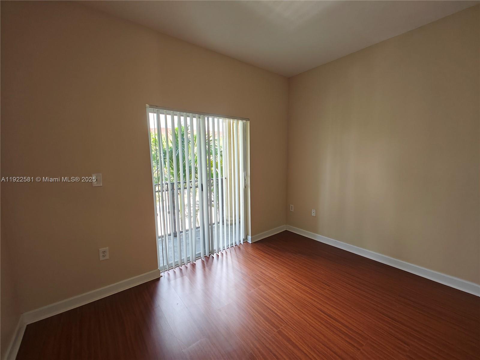 11252 Southwest 230th Terrace, Unit 11252 Miami, FL 33170 - Photo 19 of 28 an empty room with wooden floor and windows