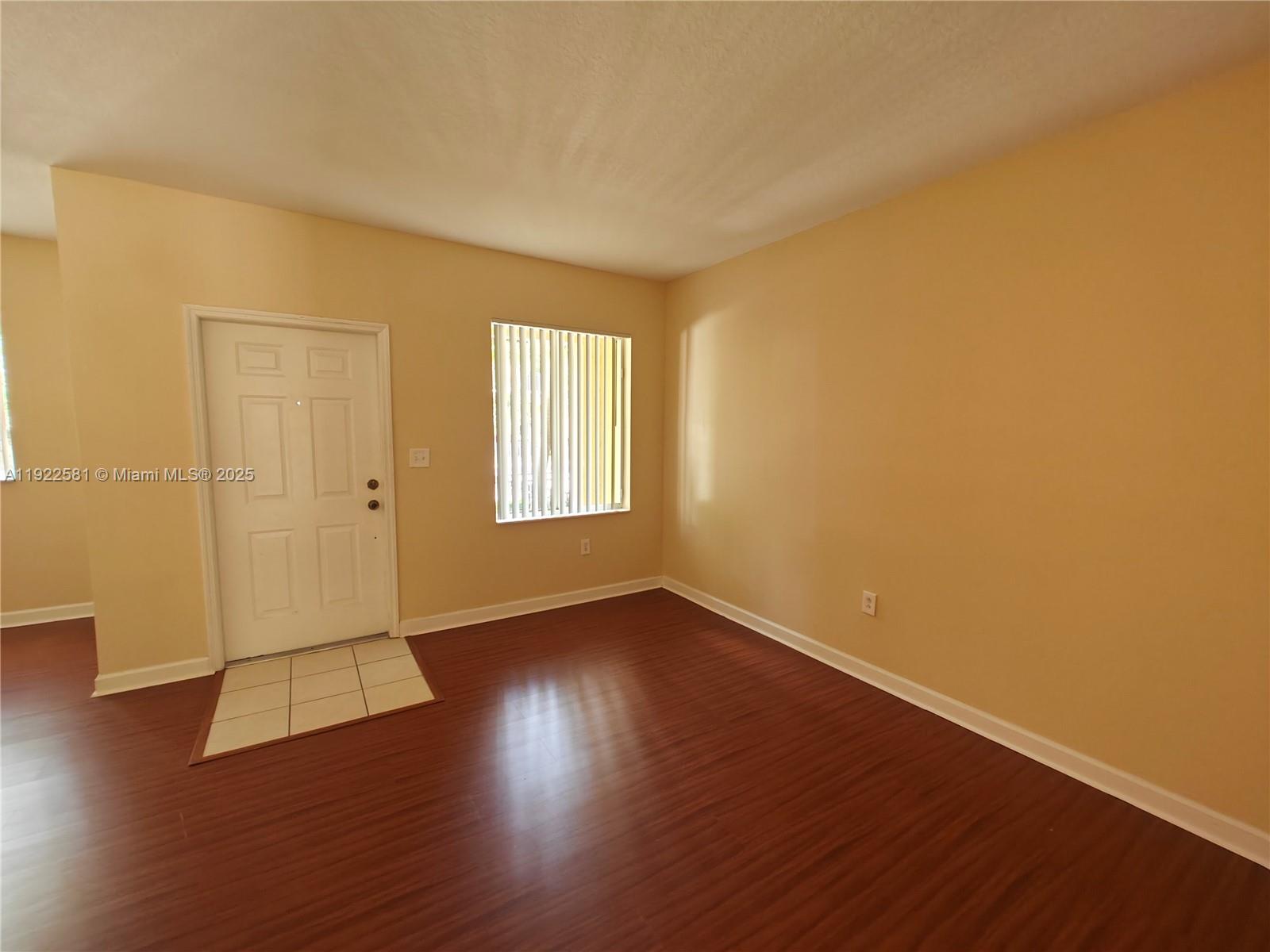 11252 Southwest 230th Terrace, Unit 11252 Miami, FL 33170 - Photo 2 of 28 an empty room with wooden floor and windows