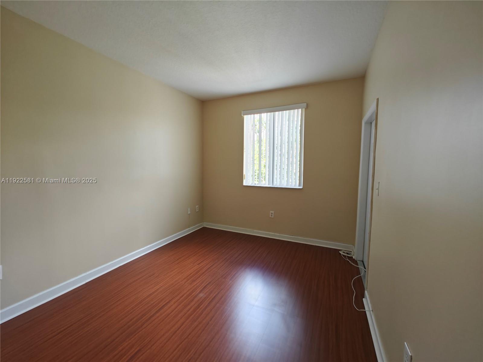 11252 Southwest 230th Terrace, Unit 11252 Miami, FL 33170 - Photo 22 of 28 an empty room with wooden floor and windows
