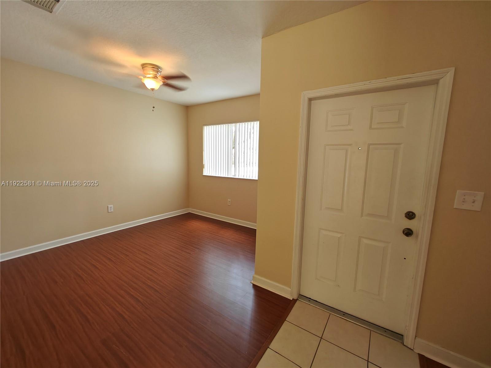 11252 Southwest 230th Terrace, Unit 11252 Miami, FL 33170 - Photo 3 of 28 an empty room with wooden floor and windows