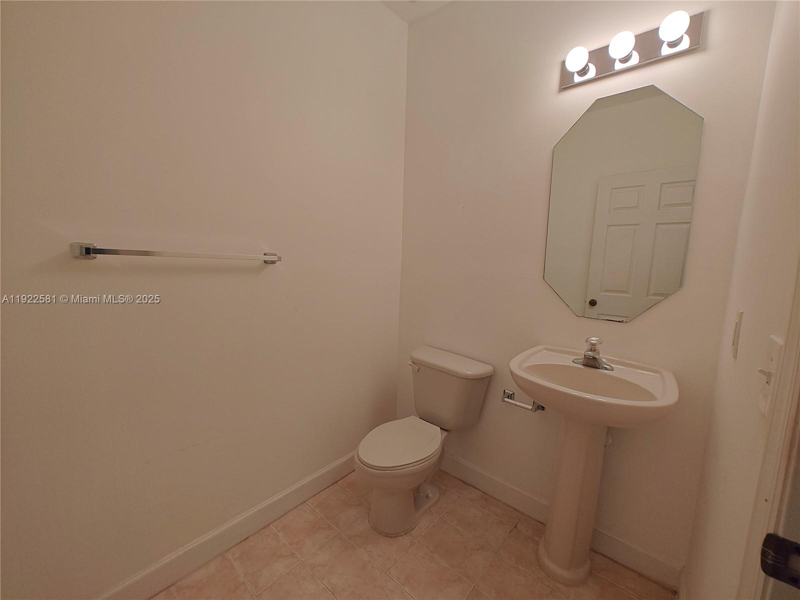 11252 Southwest 230th Terrace, Unit 11252 Miami, FL 33170 - Photo 9 of 28 a bathroom with a toilet a sink and mirror