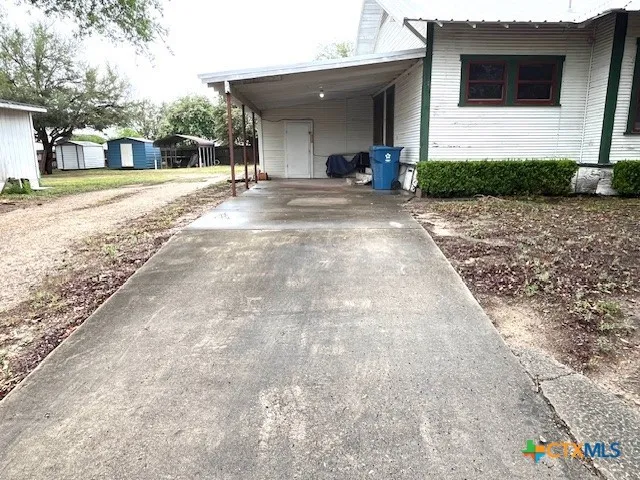 a view of a house with backyard and trees