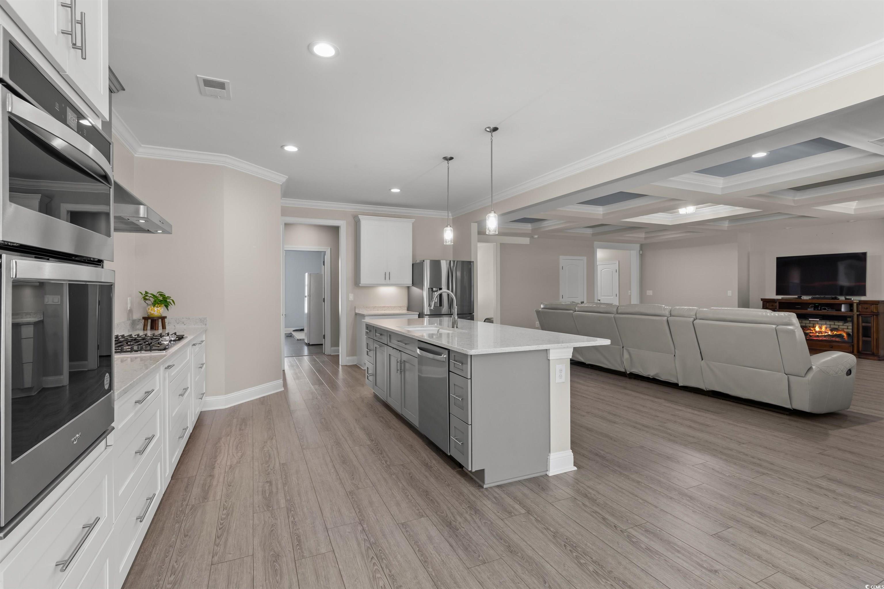3780 Dewitt Road Longs, SC 29568 - Photo 12 of 40 Kitchen featuring stainless steel appliances, gray cabinetry, decorative light fixtures, beam ceiling, and crown molding