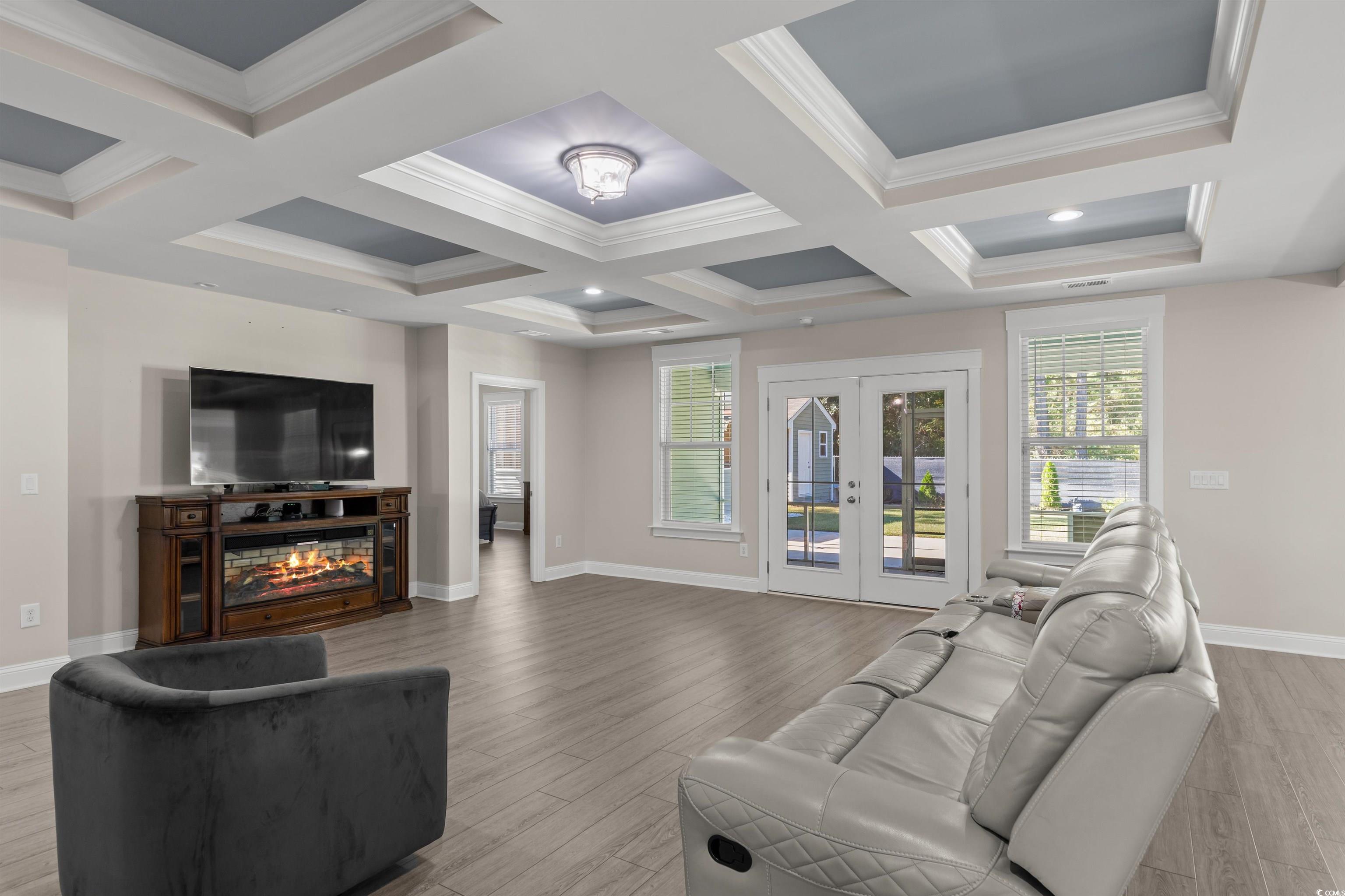 3780 Dewitt Road Longs, SC 29568 - Photo 8 of 40 Living room featuring beam ceiling, light wood-type flooring, coffered ceiling, crown molding, and a glass covered fireplace