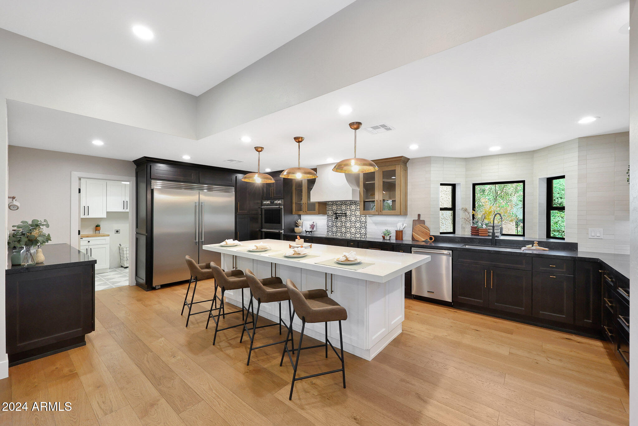 4440 East Camelback Road, Unit 32 Phoenix, AZ 85018 - Photo 19 of 54 a kitchen with stainless steel appliances kitchen island granite countertop a sink a stove a refrigerator and island with wooden floor