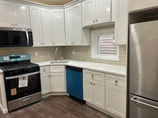 a kitchen with granite countertop white cabinets and stainless steel appliances