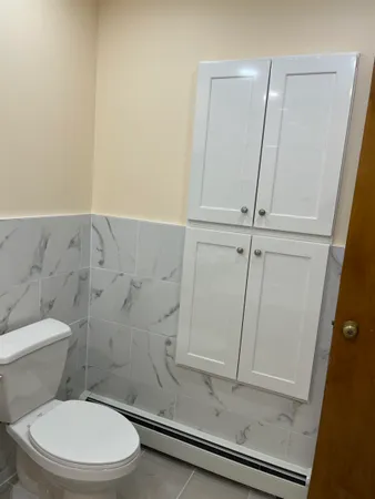 a white toilet sitting next to a shower