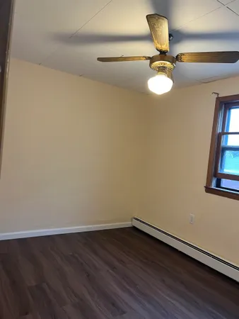 a view of a room with wooden floor and fan
