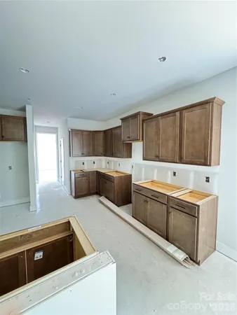 a view of a kitchen with a sink and a dishwasher with wooden cabinets