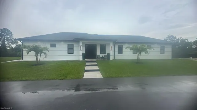 a front view of a house with a garden and yard