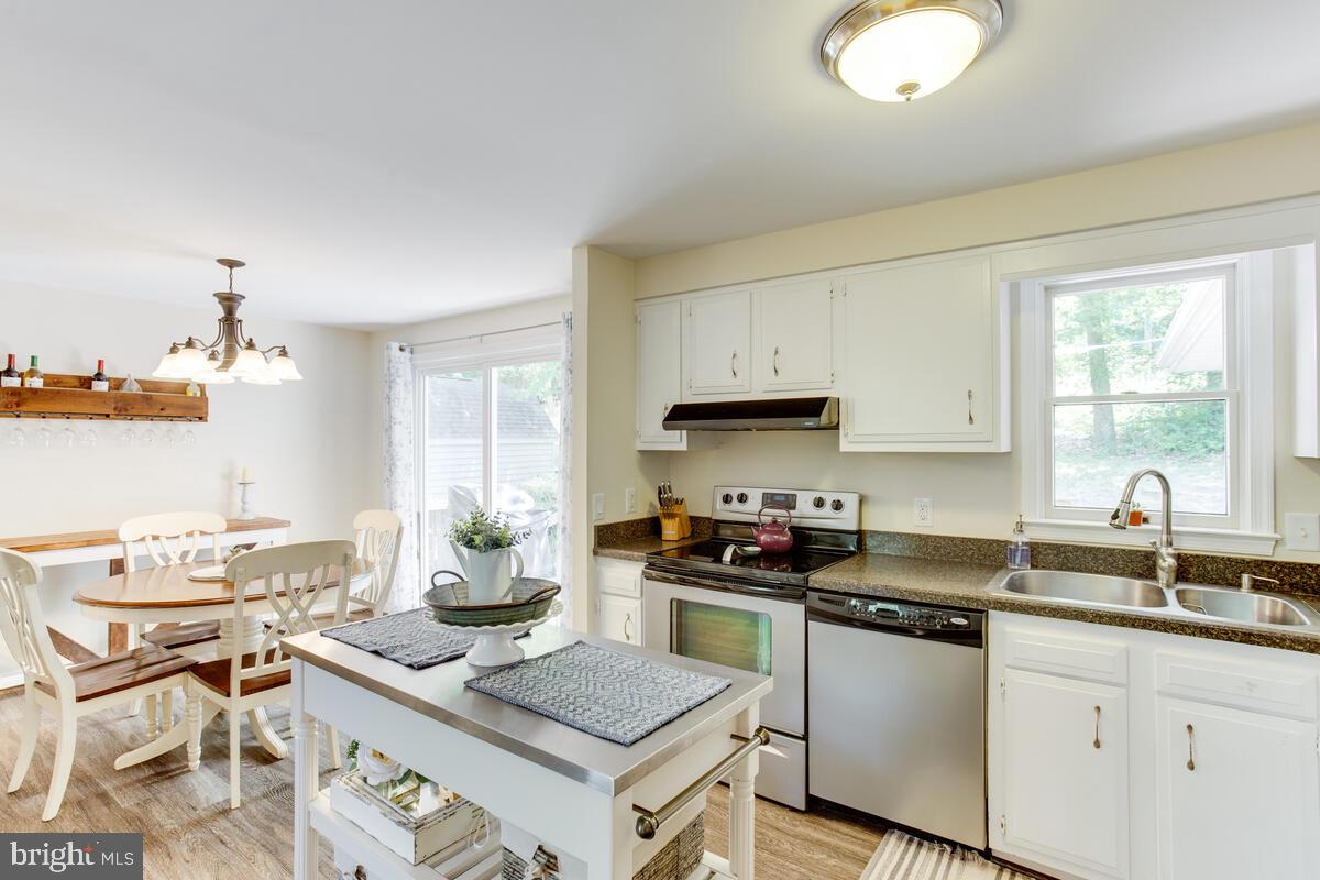 1260 Coster Road Lusby, MD 20657 - Photo 17 of 46 a kitchen with stainless steel appliances a sink stove and window