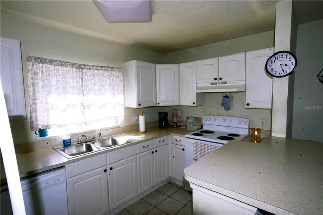 a kitchen with cabinets appliances and a window