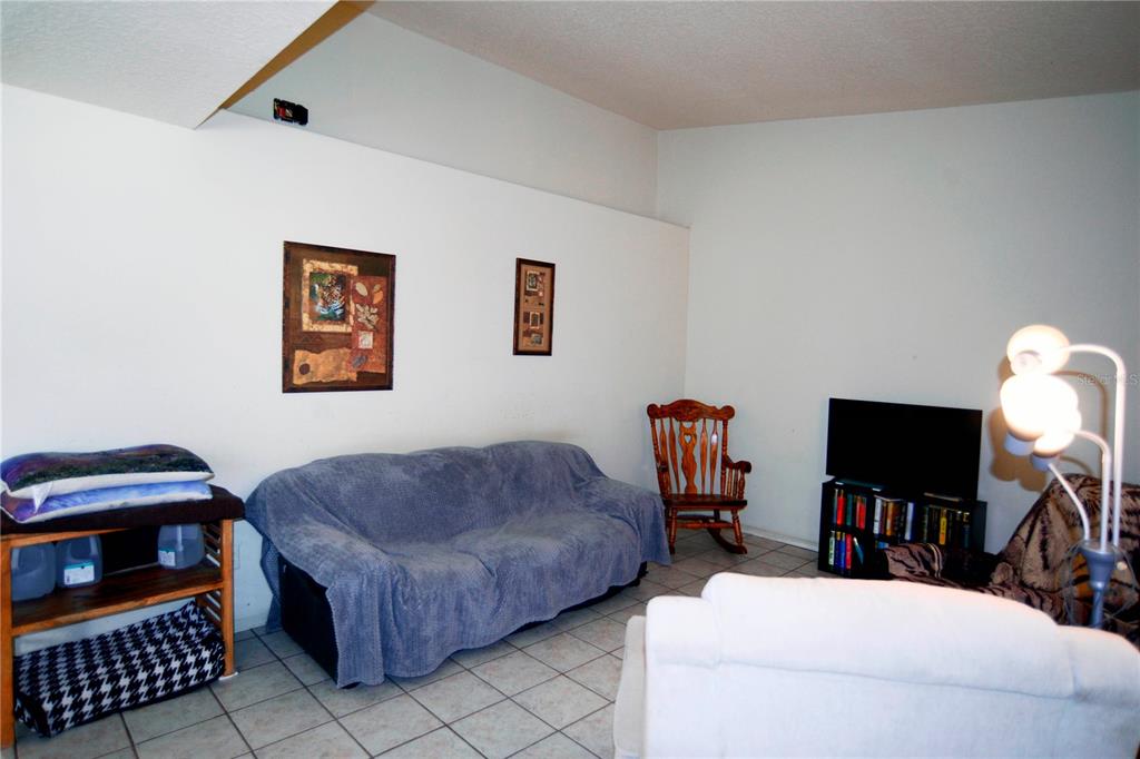 122 Ullian Trail, Unit A&B Palm Coast, FL 32164 - Photo 20 of 32 a living room with furniture a flat screen tv and a bookshelf