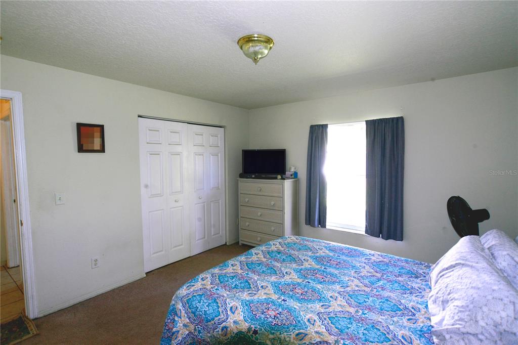122 Ullian Trail, Unit A&B Palm Coast, FL 32164 - Photo 23 of 32 a bedroom with a bed and a flat screen tv