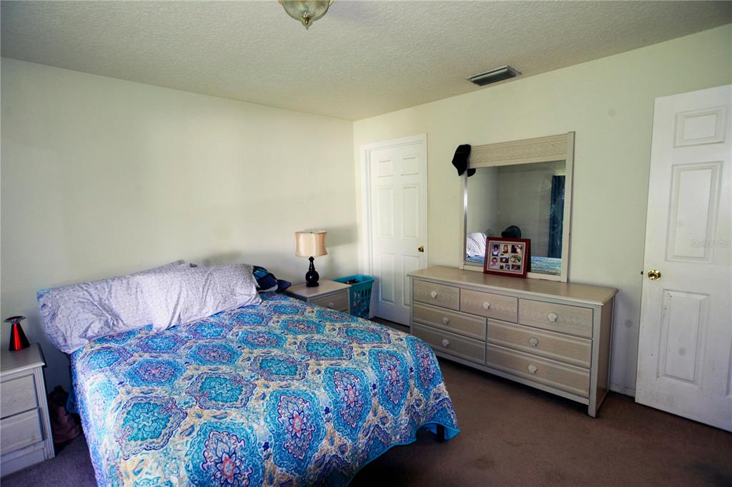 122 Ullian Trail, Unit A&B Palm Coast, FL 32164 - Photo 24 of 32 a bedroom with a bed and a dresser