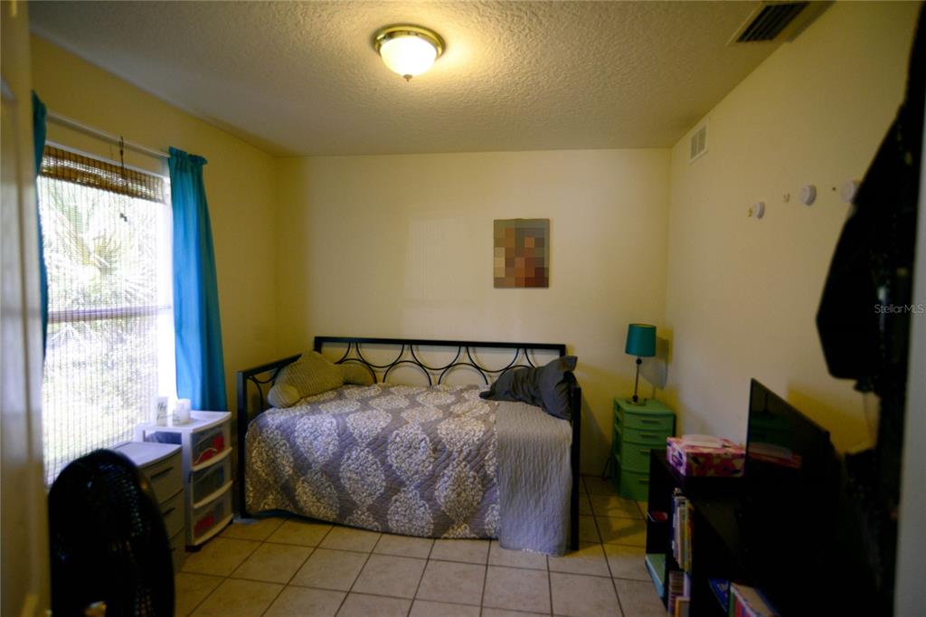 122 Ullian Trail, Unit A&B Palm Coast, FL 32164 - Photo 26 of 32 a bed sitting in a bedroom next to a window
