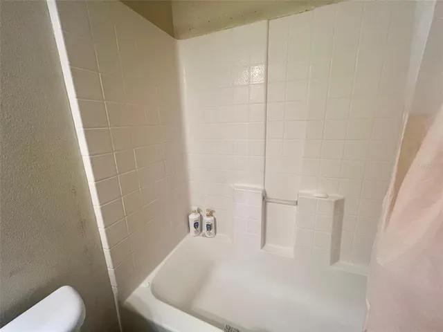 a white bath tub sitting next to a white toilet