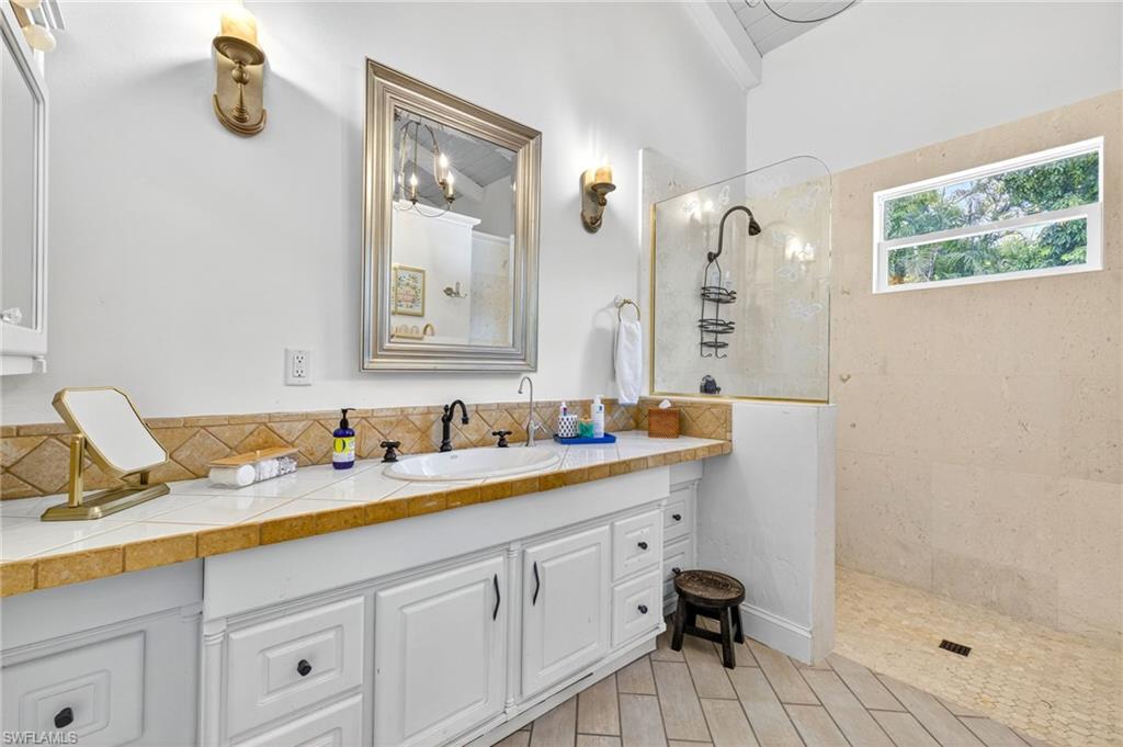 111 Caribbean Road Naples, FL 34108 - Photo 44 of 50 a bathroom with a double vanity sink and a mirror