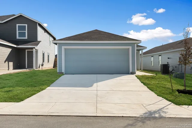 a front view of a house with a yard and a garage