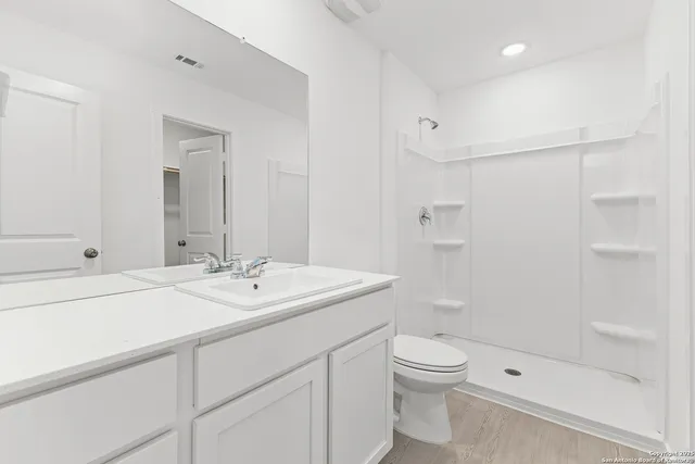 a bathroom with a sink a toilet and shower