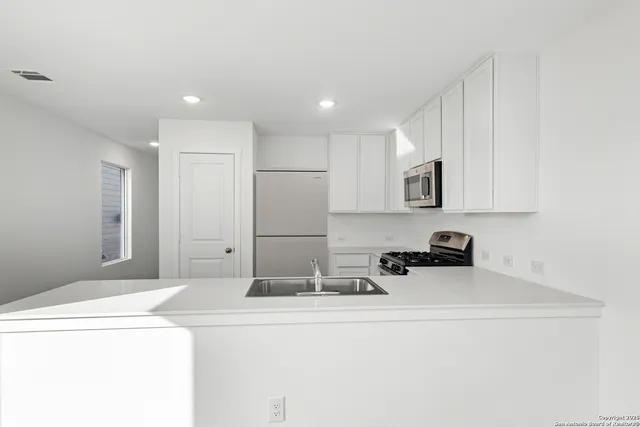 a kitchen with sink cabinets and a refrigerator