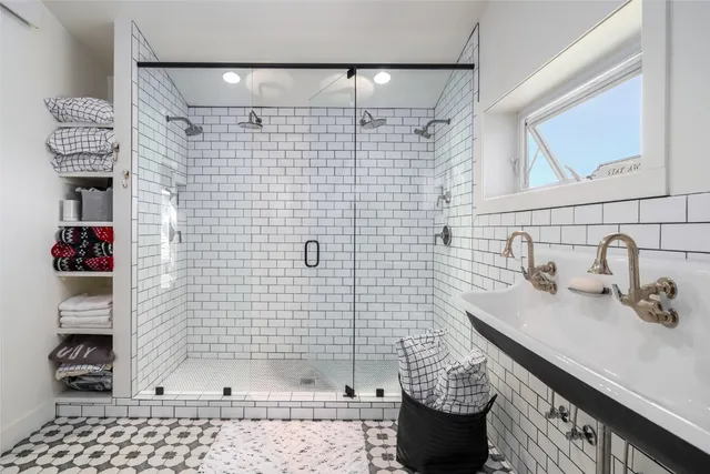 a bathroom with a sink shower and a mirror