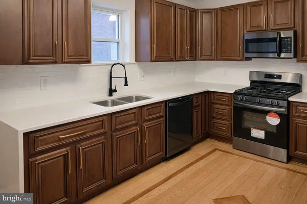 a kitchen with granite countertop a sink stainless steel appliances and cabinets