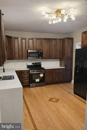 a kitchen with stainless steel appliances a stove a sink and a refrigerator