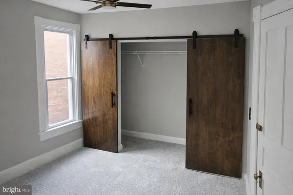 an empty room with windows and closet