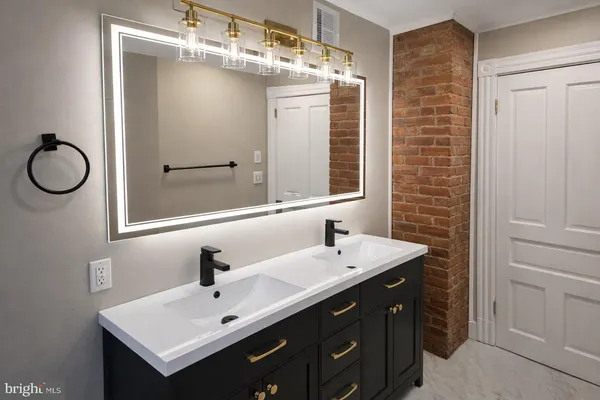 a bathroom with a sink vanity and mirror