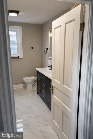 a spacious bathroom with a toilet a sink a shower and mirror