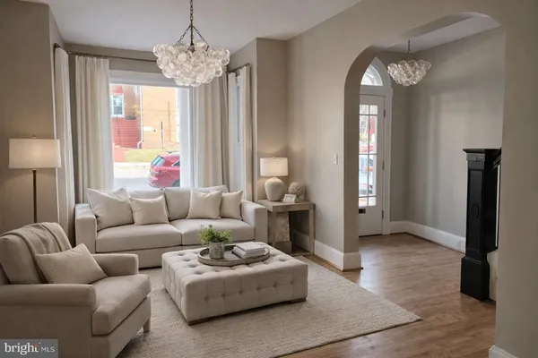 a living room with furniture a chandelier and a large mirror
