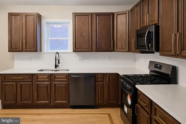 a kitchen with stainless steel appliances granite countertop a stove a sink and a microwave